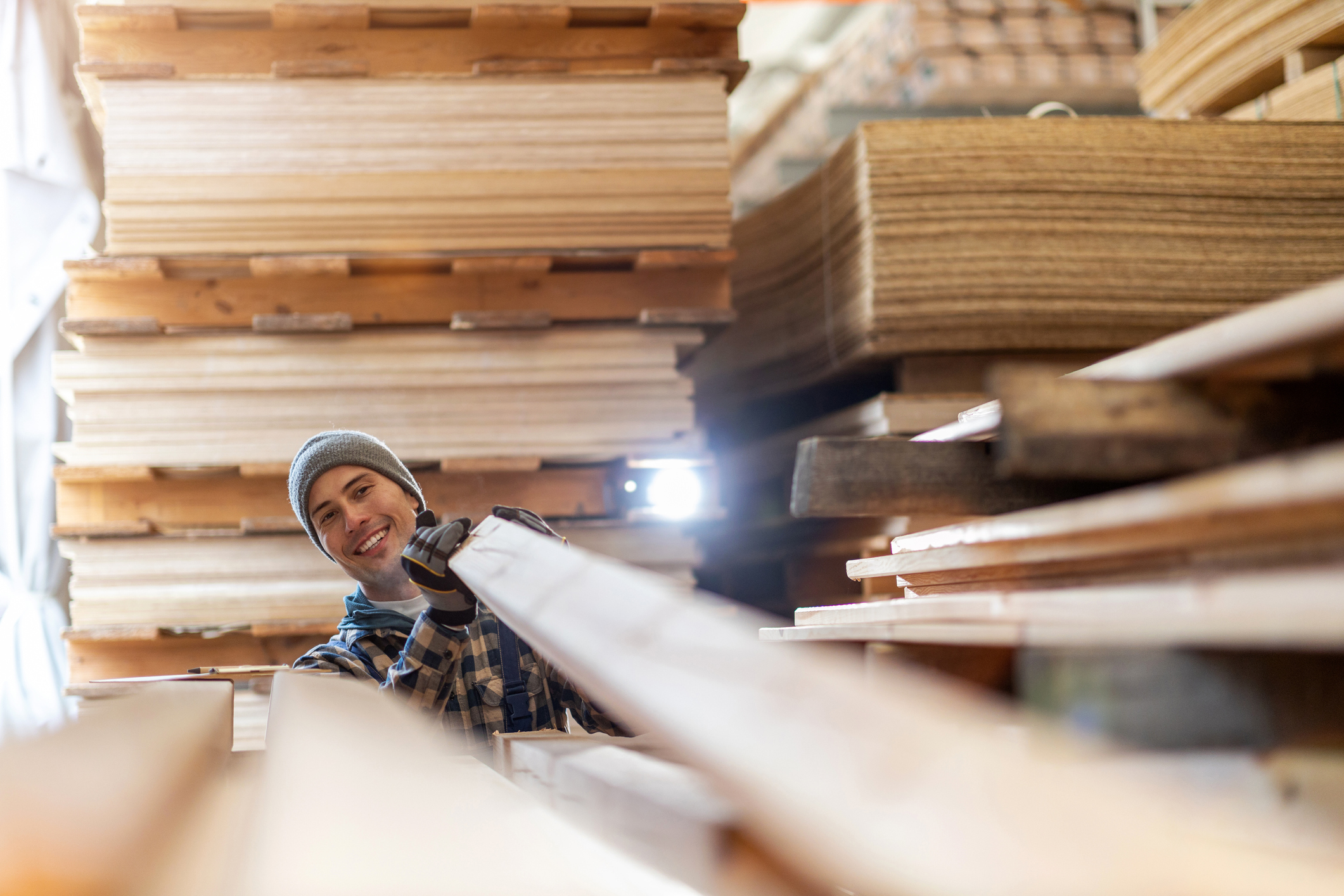 Young male worker in timber warehouse